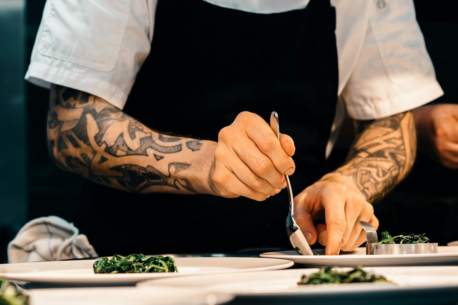 Chef dressant des assiettes au passe d'une cuisine professionnelle